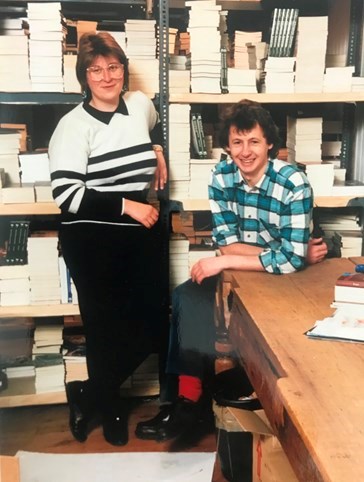 Picture of a man and woman standing in front of shelving
