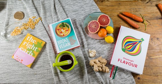Food books on  a table surrounded by food items