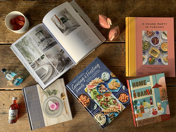 Food books scattered on a rustic table with dining accessories