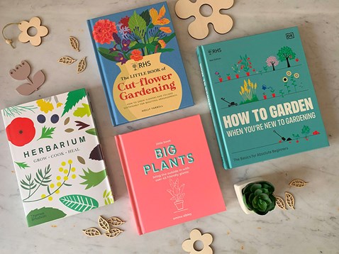 colourful gardening books laid out on a marble effect background