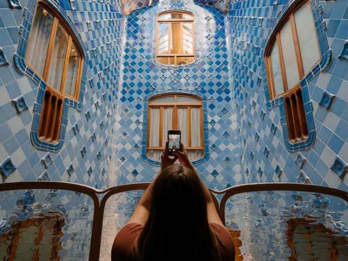Woman taking a picture of a building in Barcelona