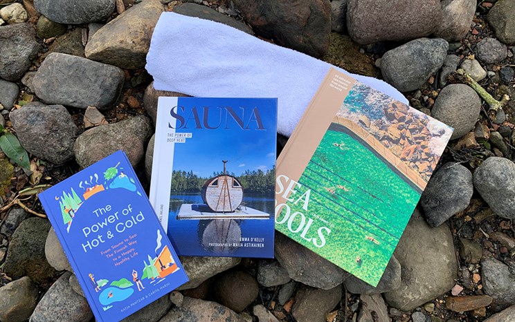 Books spread out on a pebbly shore