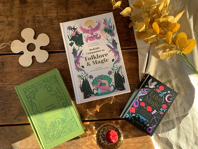 Three folklore themed books spread across a table