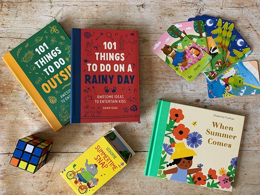Selection of children's books spread out on a faux wooden backdrop