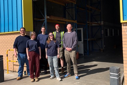 Group of colleagues standing outside a warehouse environment.