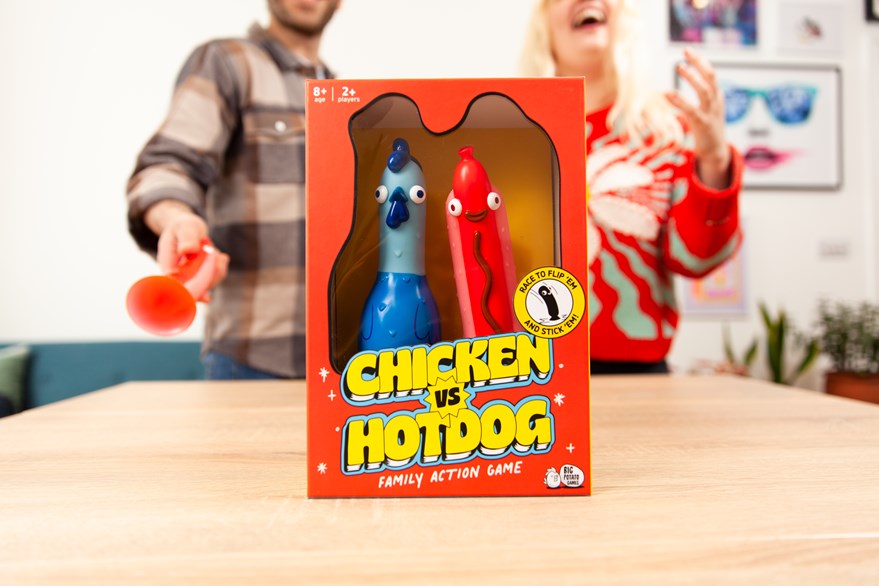 Chicken vs hotdog game in box with adult male and female playing behind.